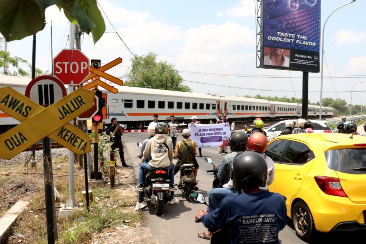 Warga pengguna jalan menyeberangi rel kereta api di perlintasan sebidang yang ada di wilayah Daop 7 Madiun, Kamis (14/12/2023)