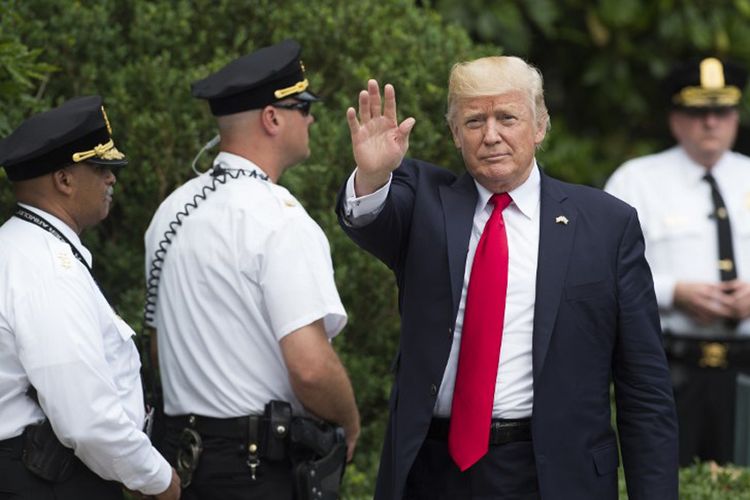 Foto yang diambil pada 16 Juni 2017 ini memperlihatkan Presiden Amerika Serikat Donald Trump yang dikelilingi petugas Secret Service berseragam, saat tiba di Marine One, Washington, DC.
 