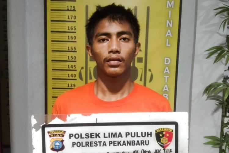 Pelaku Andika Destian saat diamankan di Mapolsek Limapuluh, Kota Pekanbaru, Riau, Minggu (19/10/2025).