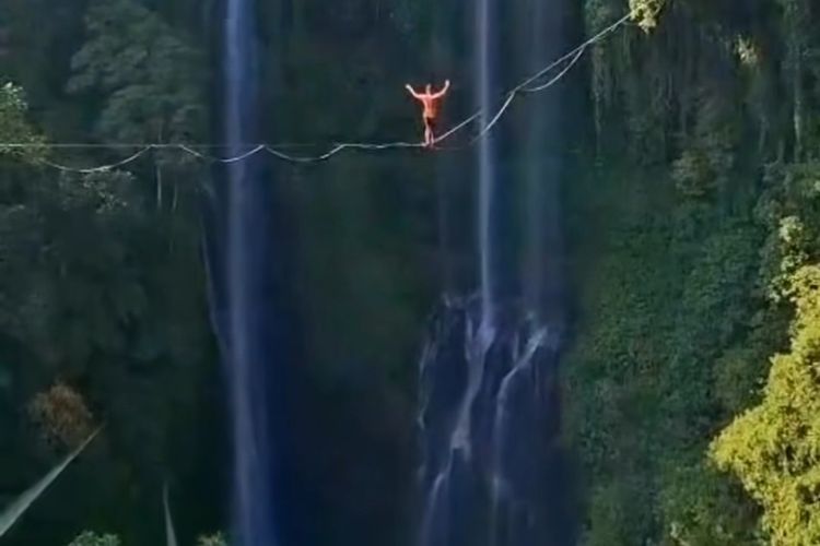 Tangkapan layar video detik-detik aksi tightrope walking di Air Terjun Sekumpul, Kabupaten Buleleng, Provinsi Bali, yang viral di media sosial. 
