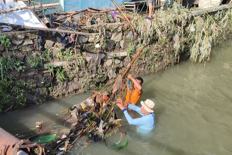 Rasiman bersama warga lainnya membersihkan material sampah di Sungai Sikenanga Desa Gamel dan Desa Sarabau Kecamatan Plered Kabupaten Cirebon, Jumat (2/1/2024). Dua desa ini terdampak banjir cukup parah tiap kali sungai sikenanga meluap