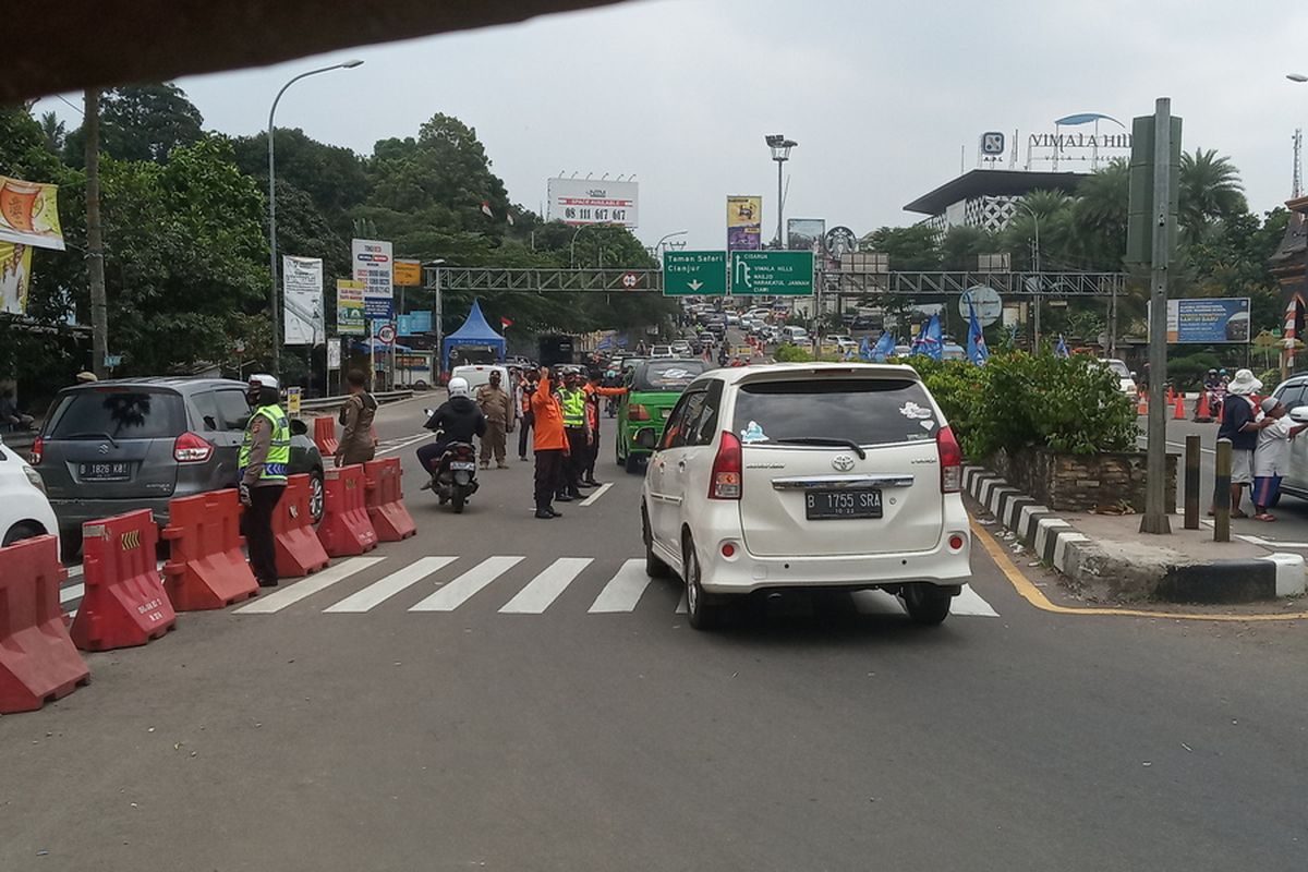 Sejumlah petugas gabungan mengkombinasikan rekayasa lalu lintas berupa ganjil genap dan sistem satu arah atau one way di Jalur Puncak Bogor, Jawa Barat, Minggu (19/9/2021).