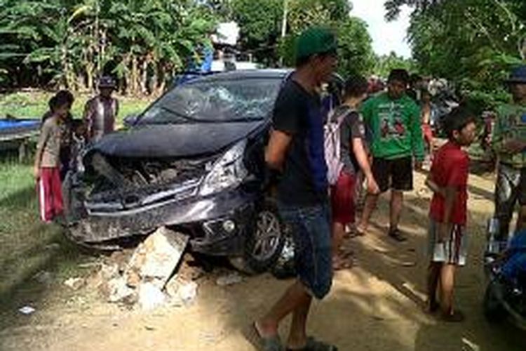 Minibus milik pelaku perampokan yang diamuk warga dan menewaskan seorang pelaku tengah menjadi tontonan warga Desa Labotto, Kecamatan Cenrana, Kabupaten Bone, Sulawesi Selatan. Rabu, (02/04/2014).