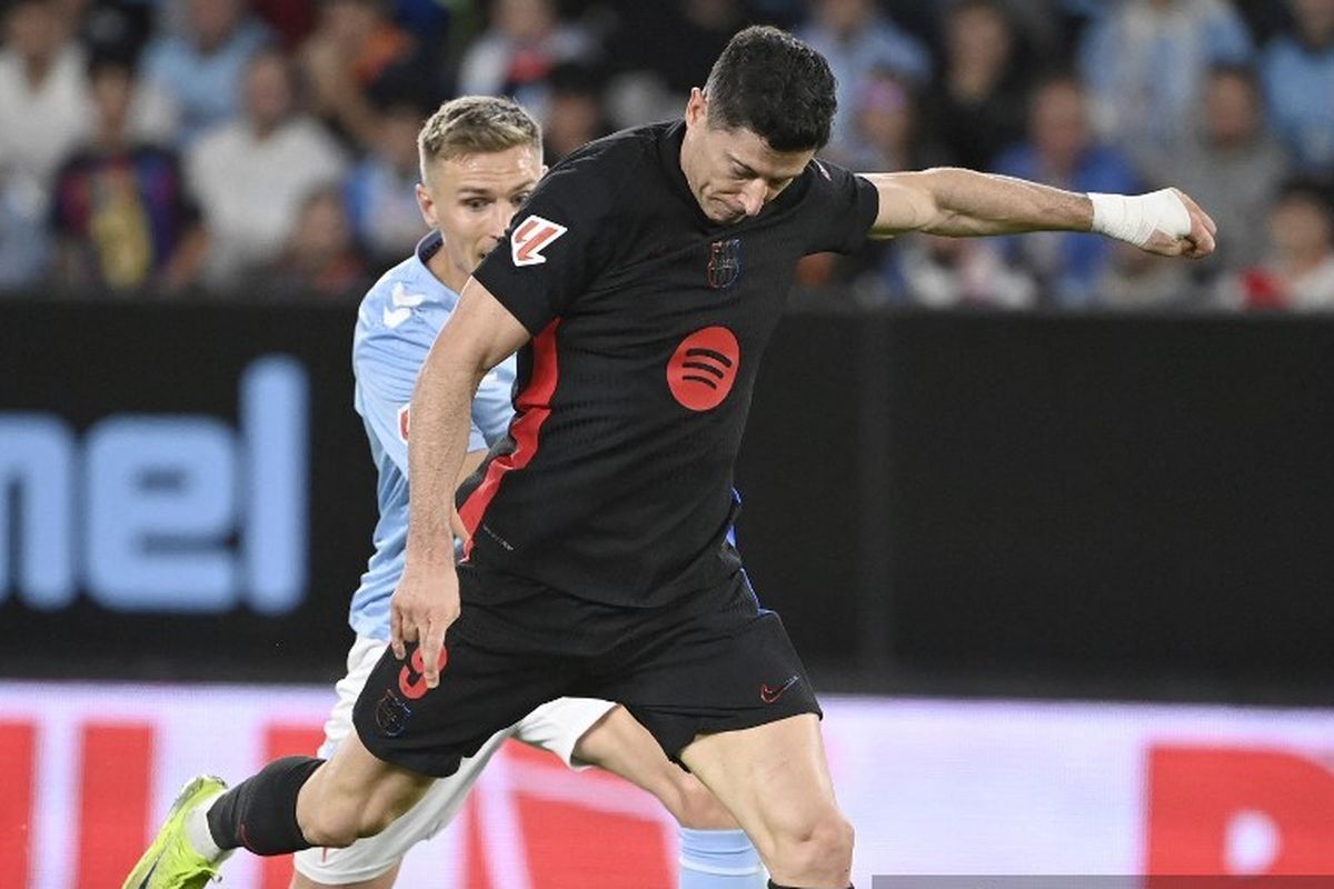Penyerang asal Polandia, Robert Lewandowski, melepasa tembakan dalam pertandingan Liga Spanyol antara Celta Vigo vs Barcelona di Stadion Balaidos di Vigo pada 23 November 2024.. (Photo by MIGUEL RIOPA / AFP)