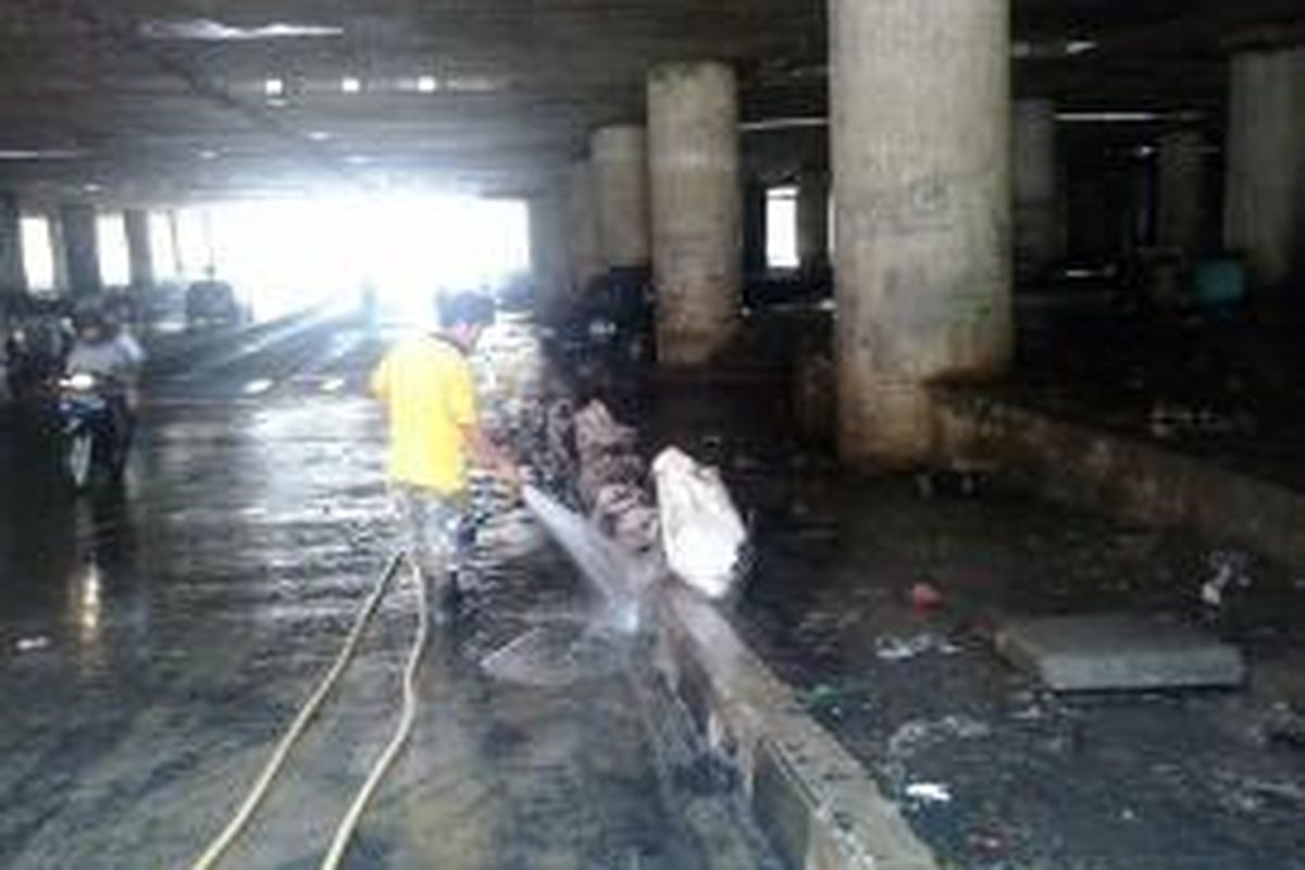 Petugas PPKK membersihkan Lumpur sisa banjir yang menggenangi Terowongan Kemayoran ini selama sepekan, Senin (12/2/2015)