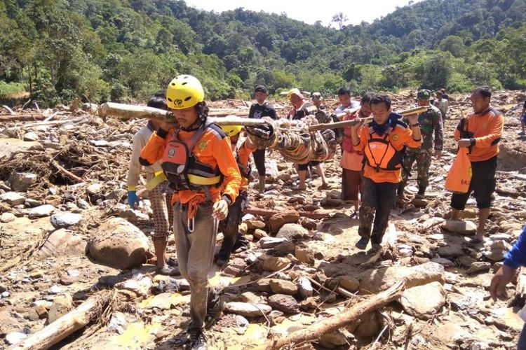 Petugas saat melakukan evakuasi korban dari lokasi banjir bandang di Desa Bongkaras, Kecamatan Silima Pungga-pungga, Kabupaten Dairi, Jumat (21/12/2018).