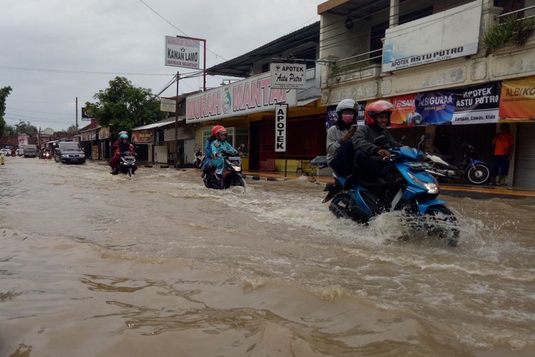 Kendaraan melintas di ruas jalan yang tergenang air akibat luapan Kali Dengkeng di Kecamatan Cawas, Kabupaten Klaten, Jawa Tengah, Kamis (7/3/2019).