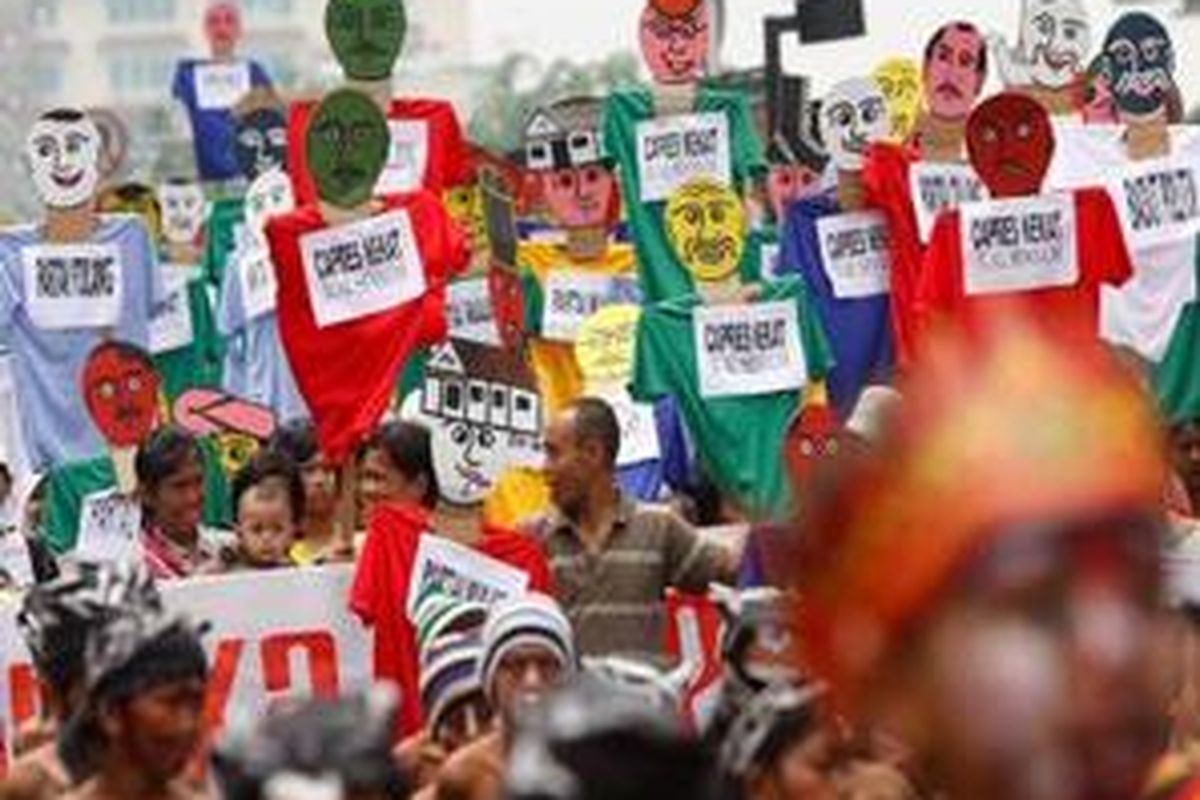 Peserta karnaval 60 Tahun Deklarasi HAM mengusung boneka dengan kostum warna yang mencolok.