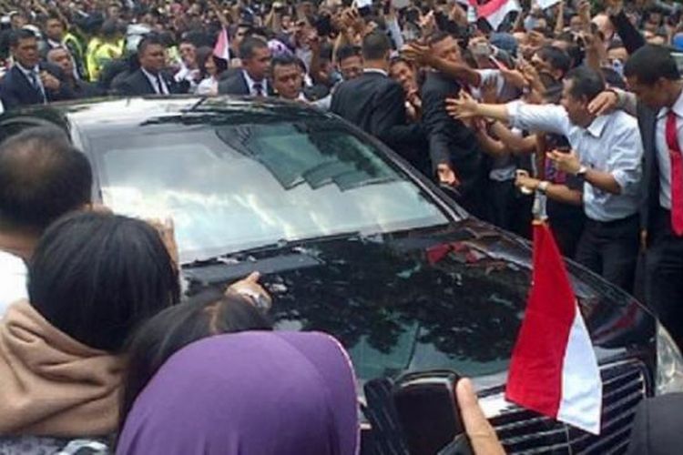 Massa mendekati mobil RI 1 yang ditumpangi Presiden Joko Widodo di Jalan Sudirman, Jakarta Pusat, Senin (20/10/2014). 