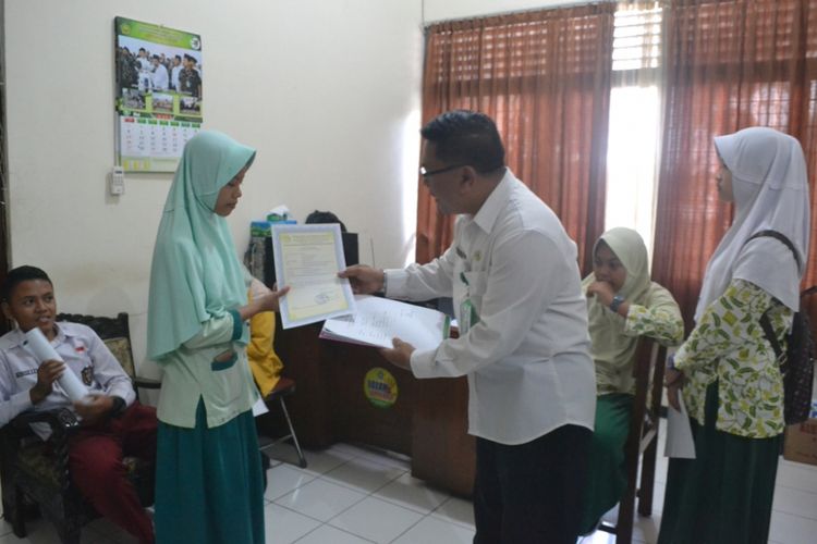 Salah satu calon siswa baru yang telah mengikuti uji petik hafalan Al-Quran di Kantor Kementerian Agama sebelum mendaftar di sekolah yang diinginkan di Kota Magelang, Jawa Tengah, Kamis (7/6/2018).
