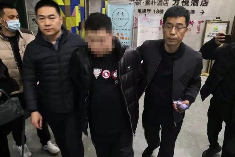 Polisi menangkap Zhang Nan (tengah) yang mengaku berkencan dan menipu puluhan wanita di Provinsi Henan, China.