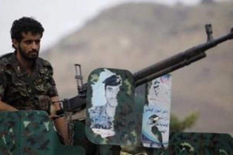Seorang tentara Yaman berjaga di atas kendaraan militer yang dilengkapi senapan mesin di ibu kota, Sanaa.