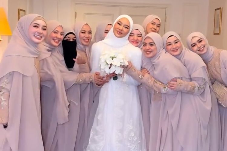 Bridesmaid Dara Arafah tampil serasi dalam abaya nude di Madinah. Elegan, lembut, dan selaras dengan suasana sakral pernikahan di Masjid Nabawi.