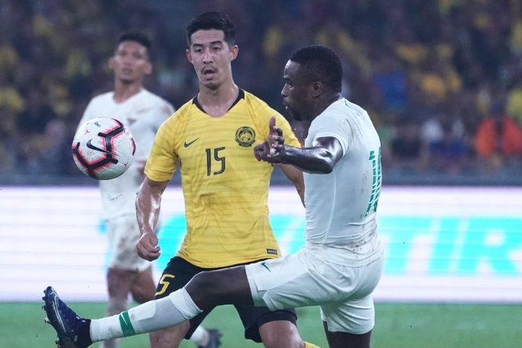 Brendan Gan (kiri-kuning) berebut bola dengan Greg Nwokolo (kanan-putih) pada laga Malaysia Vs Indonesia dalam lanjutan Kualifikasi Piala Dunia 2022 Grup G di Stadion Nasional Bukit Jalil, Selasa 19 November 2019.
