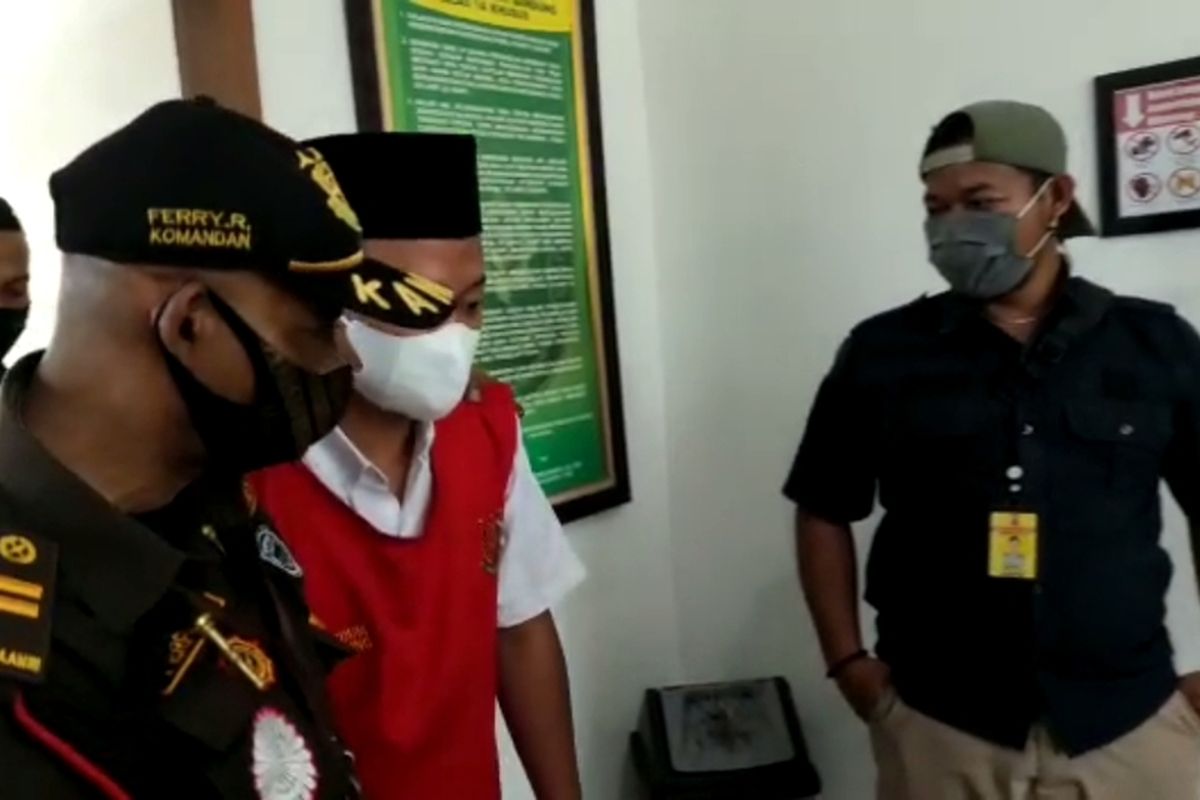 Herry Wirawan yang mengenakan kopiah hitam dan rompi merah hendak mengikuti sidang.