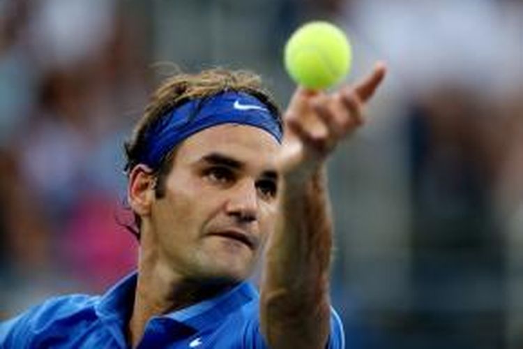 Petenis Swiss, Roger Federer melakukan servis saat menghadapi Tommy Robredo dari Spanyol di babak keempat US Open, Senin (2/9/2013).
