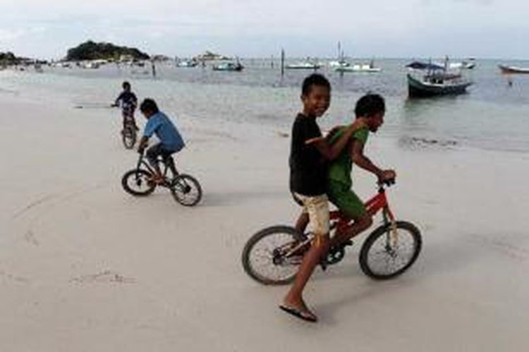 Bocah bermain sepeda di Pantai Tanjung Kelayang, Belitung, Bangka Belitung, Selasa (12/4/2011). Pulau Belitung terkenal dengan keindahan wisata pantai pasir putih berbatu granit artistik.