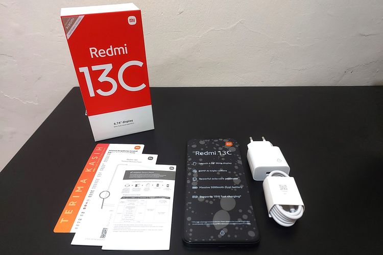Kotak penjualan Redmi 13C 4G mencakup satu unit smartphone Redmi 13C 4G, SIM card ejector, buku panduan penggunaan, kartu garansi resmi, kartu pernyataan terima kasih dari Xiaomi, kabel USB-C, dan adapter daya 10 Watt.