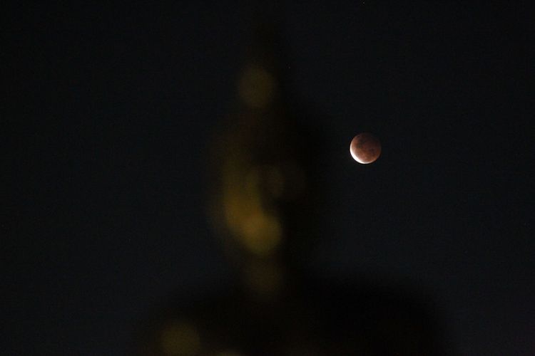 Gerhana bulan total dengan latar depan patung Budha di Vihara Hemadhiro Mettavati, Cengkareng, Jakarta Barat, Rabu (26/5/2021). Gerhana Bulan Total tanggal 26 Mei 2021 ini dikenal juga dengan Super Blood Moon (Bulan Merah Super), karena terjadi saat bulan di di jarak terdekat dengan Bumi (Perigee).