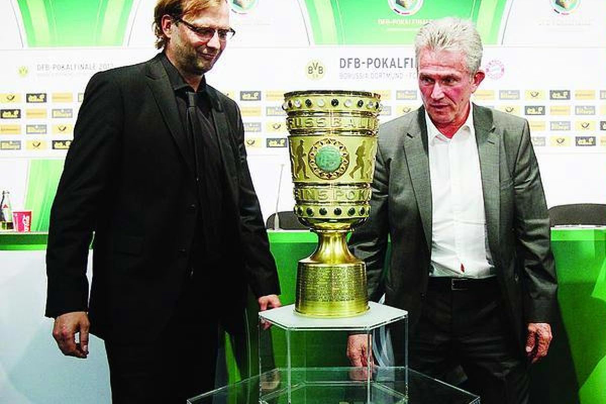  Pelatih Bayern Muenchen Jupp Heynckes (kanan) dan Pelatih Borussia Dortmund Juergen Klopp berfoto mengapit Piala Jerman setelah konferensi pers di  Stadion Olimpiade, Berlin, Jerman, Jumat (11/5).  Dortmund bertemu   Bayern, Sabtu (12/5), di final Piala Jerman.