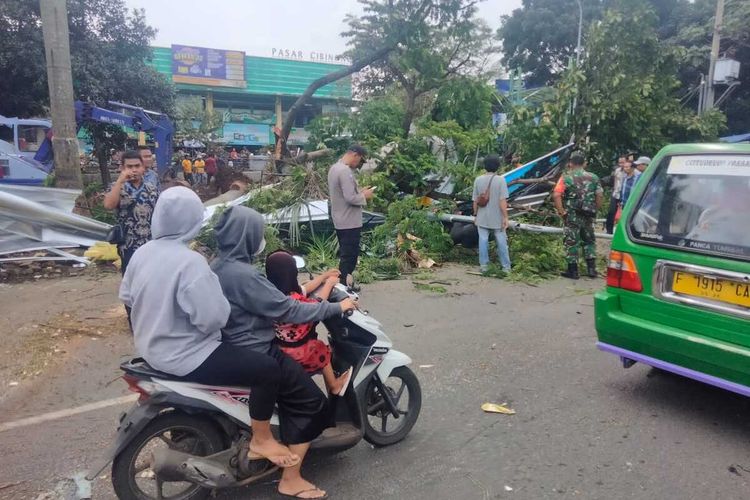 Tim gabungan yang terdiri dari aparat Kepolisian dan TNI, BPBD, melakukan evakuasi dua pohon besar tumbang di pinggir jalan atau tepatnya Depan Pasar Cibinong, Kecamatan Cibinong, Kabupaten Bogor, Jawa Barat, pada Kamis (20/10/2022).