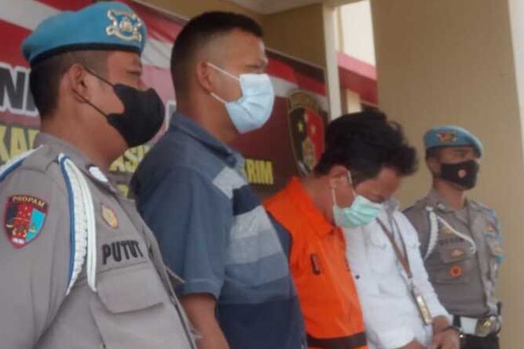 Tersangka JAB diapit sejumlah anggota polisi di Mapolres Cianjur, Selasa (3/5/2021). JAB bersama tersangka lainnya berinisial AR ditetapkan sebagai tersangka kasus pemalsuan surat hasil rapid test antigen.