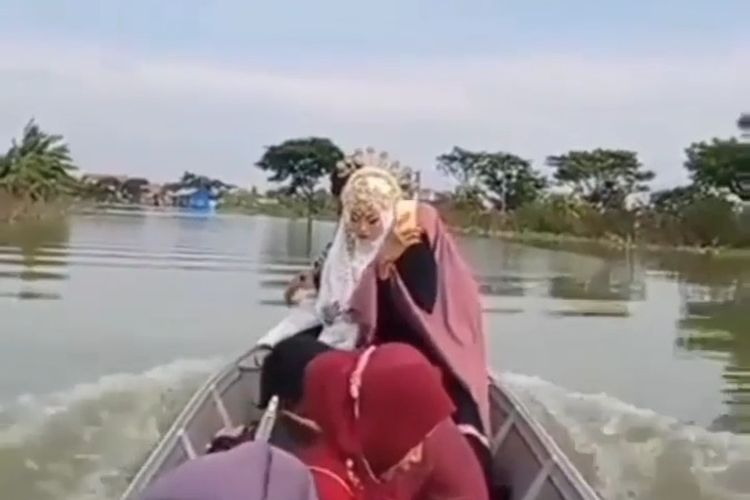 Tangkapan layar salah satu video yang beredar, yang memperlihatkan mempelai wanita sedang menaiki perahu akibat banjir Bengawan Njero di Kabupaten Lamongan.