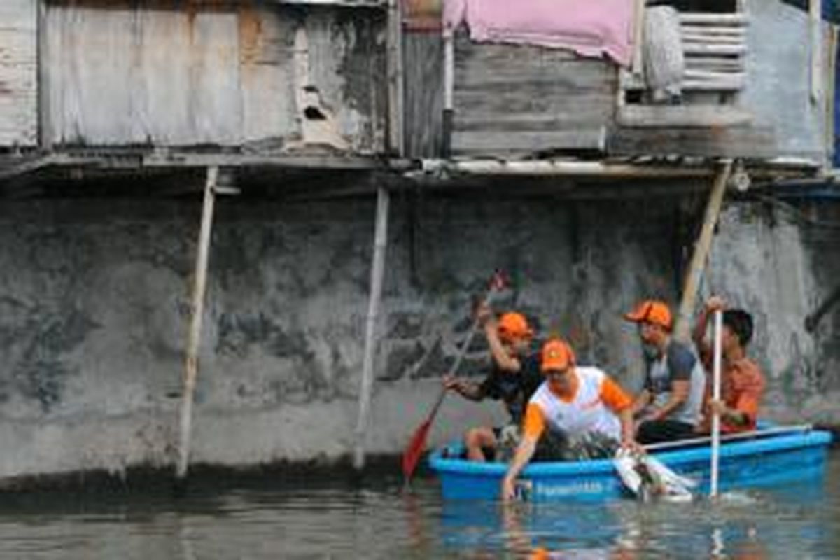 Arsono (35) bersama personel dari Komunitas Pemuda Peduli Lingkungan (Kompling) membersihkan laut dari sampah rumah tangga di bawah jamban sebuah rumah, RT 01 RW 04 Kelurahan Penjaringan, Kecamatan Penjaringan, Jakarta Utara, Minggu (16/11/2014).