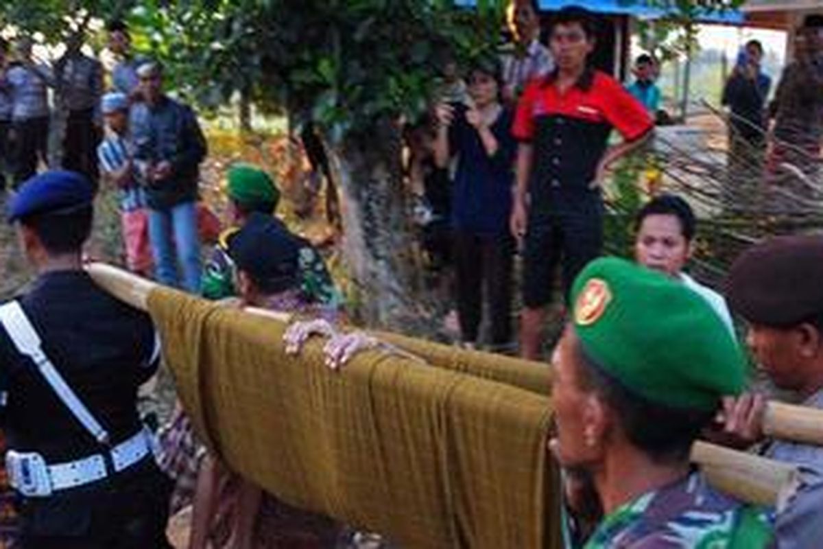 Anggota Brimob Polda Jawa Timur, mengevakuasi korban bentrok kaum Syiah di Desa Karang Gayam, Kecamatan Omben, Kabupaten Sampang.