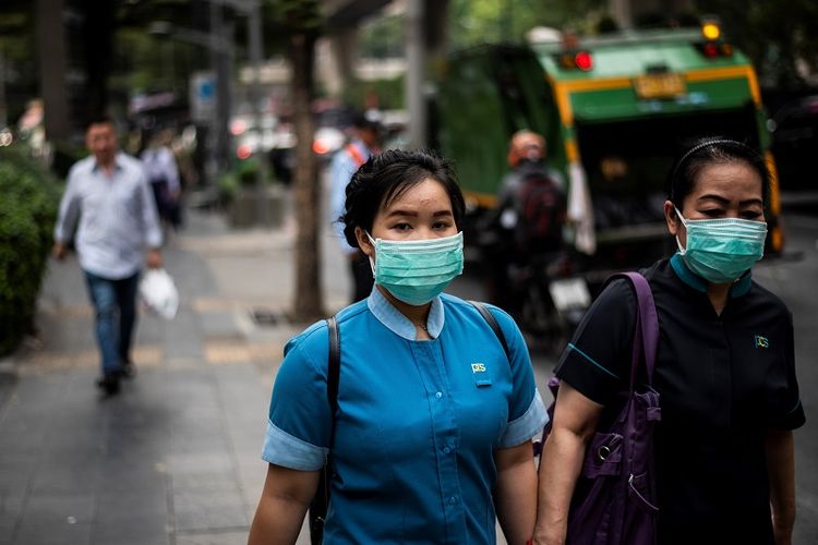 Para pejalan kaki di Bangkok, Thailand terpaksa menggunakan masker untuk mengurangi dampak dari polusi udara yang amat buruk di kota itu. 