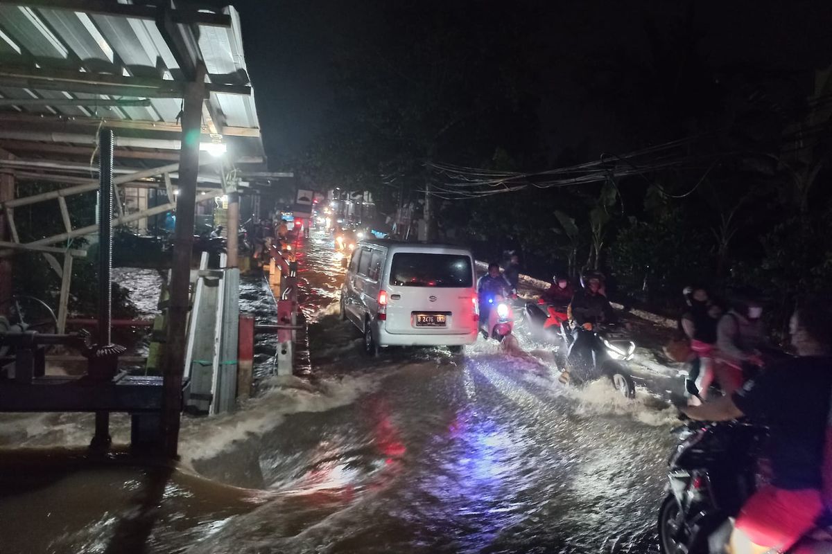 Luapan Kali Buk di Jalan Raya Pitara, Pancoran Mas, Depok, meluap ke badan jalan pada Jumat (15/7/2022). Imbasnya sejumlah pengendara motor mogok akibat nekat melintasi banjir.