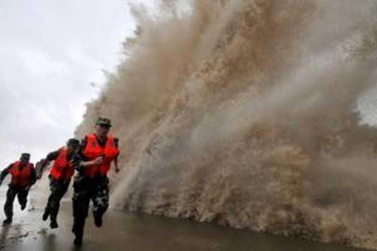Pasukan China berlari bersamaan saat gelombang besar menghantam pesisir Wenlin di Provinsi Fujian, China. Topan Fitow dengan kecepatan 100 kilometer per jam adalah topan ke-23 yang menghantam China tahun ini.