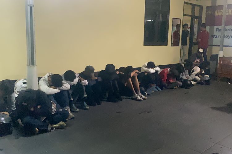 Sebanyak 13 orang supertor Persija Jakarta yang tengah berada di Polsek Warudoyong Kota Sukabumi tertunduk malu, mereka diamankan dari buntuk aksi pengrusakan pagar rumah milik warga di Jalan Pajagalan, Kota Sukabumi, Senin (23/9/2024). 