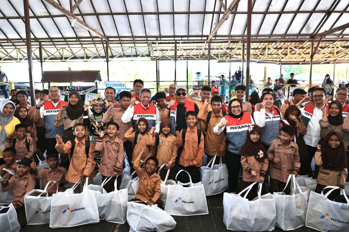 Jajaran Pertamina Group bersama anak-anak Kampung Atas Air Balikpapan saat pemberian  bantuan seragam dan perlengkapan sekolah dalam rangka Hari Anak Nasional 2025.