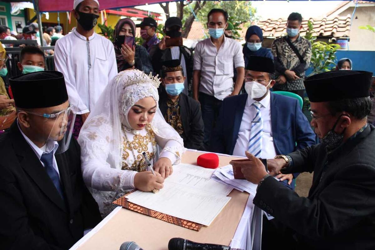 Akad nikah pasangan Indri dan Andri berlangsung khidmat di tengah duka mendalam karena harus kehilangan kedua orangtuanya dalam musibah longsor. Akad berlangsung di Desa Sawahdadap, Cimanggung, Sumedang, Kamis (28/1/2021). Wakil Bupati Sumedang jadi saksi nikah keduanya. 