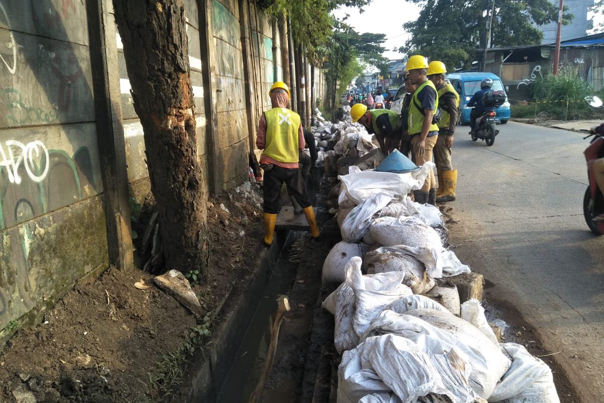 Petugas PT PLKJ tengah melakukan normalisasi drainaae di sepanjang jalan Limo, Limo, Depok pada Senin (28/3/2022).
