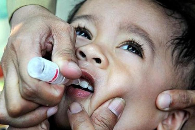 Seorang bocah mendapatkan imunisasi polio.