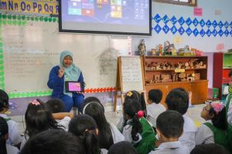 Nura Uma Annisa, guru komputer TK Islam Al-Azhar 22 Semarang, menerangkan materi pelajaran dengan tablet di depan kelas, Selasa (17/12/2013)
