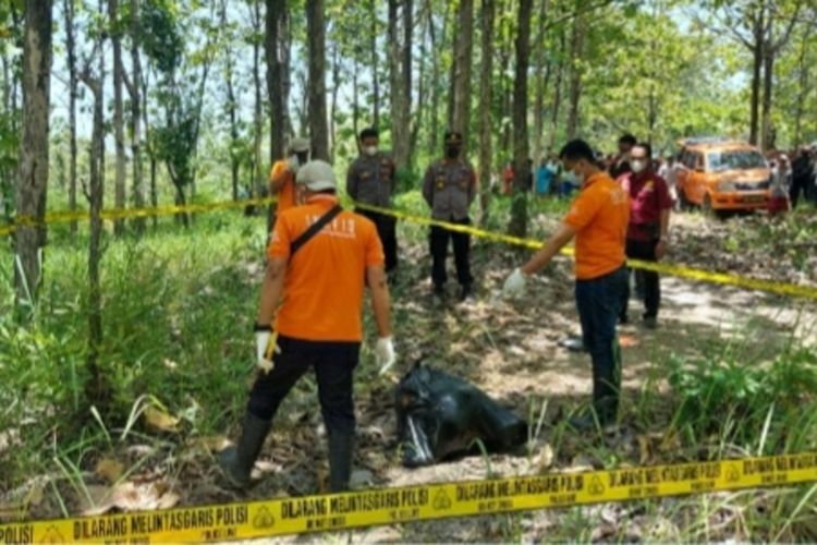 Polisi mengevakuasi mayat perempuan terbungkus kantong plastik hitam di kawasan hutan wilayah Dusun Besole, Desa Juworo, Kecamatan Geyer, Kabupaten Grobogan, Jawa Tengah, Rabu (13/10/2021).