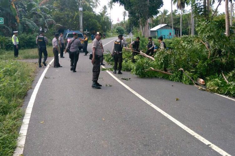 Aparat TNI Polri bersenjata lengkap berupaya membuka blokade jalan di desa Waesamu, Kecamatan Kairatu Barat, Kabupaten Seram Bagian Barat Maluku, Selasa (18/4/2017). Blokade jalan dilakukan warga menyusul aksi pelemparan bom oleh orang tidak dikenal di dua rumah warga setempat