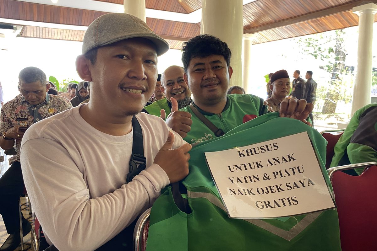 Diki Wahyudi (28), driver ojek online (ojol) warga Kelurahan Margadadi, Kabupaten Indramayu, Jawa Barat, saat menunjukkan tulisan besar 'KHUSUS UNTUK ANAK YATIM DAN PIATU NAIK OJEK SAYA GRATIS' yang ia tempelkan di bagian punggung jaket ojol miliknya ketika ditemui di Pendopo Indramayu, Jawa Barat, Selasa (7/10/2025).