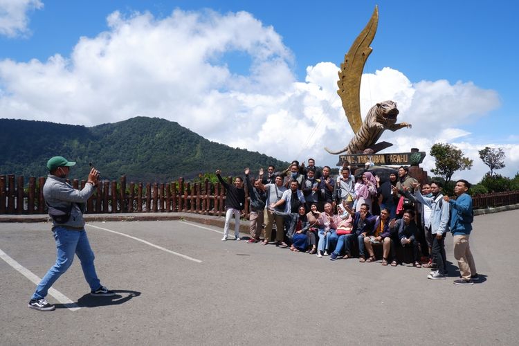 Ilustrasi pengunjung Gunung Tangkuban Parahu sedang berfoto.