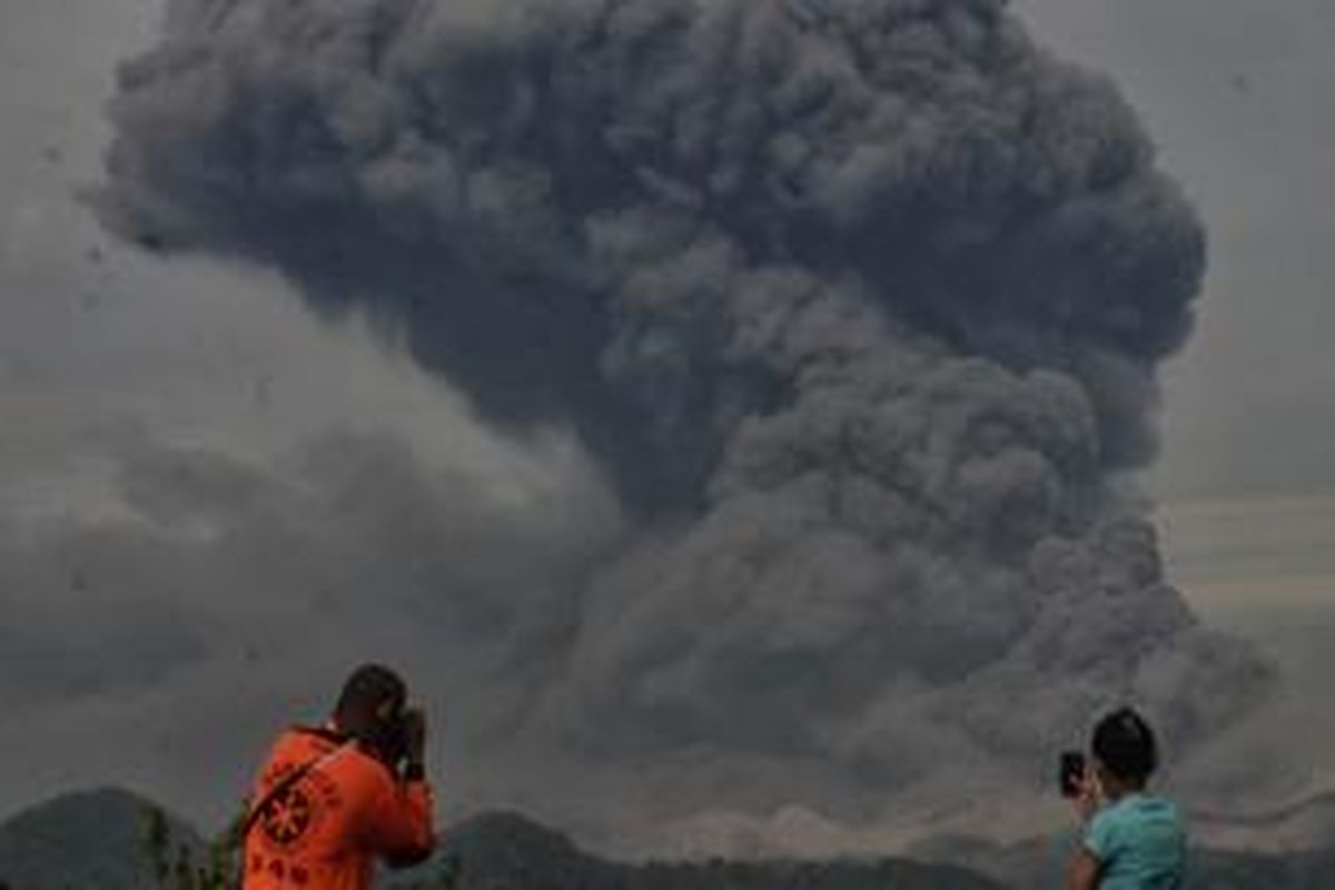 Warga dan tim SAR mengamati abu vulkanik yang meninggi keluar dari Gunung Kelud yang terlihat dari jarak lima kilometer di Desa Penataran, Kecamatan Nglegok, Kabupaten Blitar, Jumat (14/2/2014). Menurut Pusat Vulkanologi dan Mitigasi Bencana Geologi (PVMBG), Gunung Kelud yang meletus pada Kamis lalu sekitar pukul 22.30 WIB bersamaan keluarnya tremor tersebut, mengalami 442 kali gempa vulkanik dangkal. SURYA/AHMAD ZAIMUL HAQ