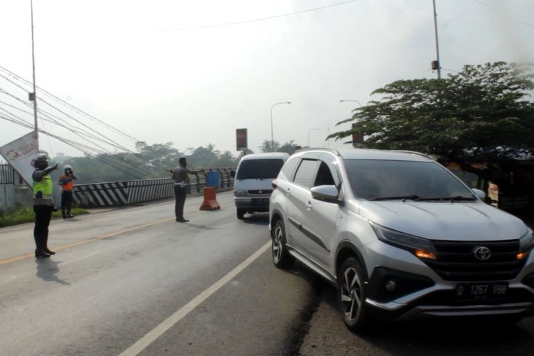 Petugas di kawasan Jembatan Citarum yang merupakan wilayah perbatasan antara Cianjur dan Bandung Barat, mengarahkan kendaraan ke bahu jalan untuk diperiksa, Kamis (6/5/2021). Pemeriksaan kendaraan terkait larangan mudik lebaran tahun ini.