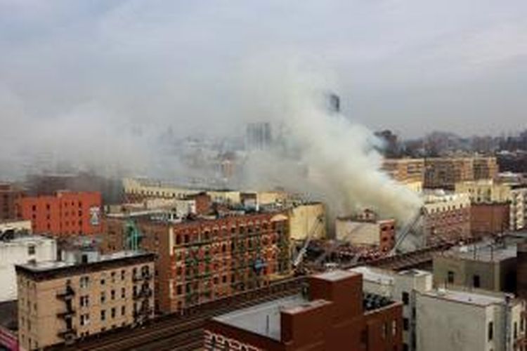 Asap tebal terlihat di lokasi runtuhnya sebuah gedung apartemen di Harlem Timur, New York, Rabu (12/3/2014). Sebelumnya terdengar ledakan keras yang bisa dirasakan warga di sekitar lokasi gedung tersebut.