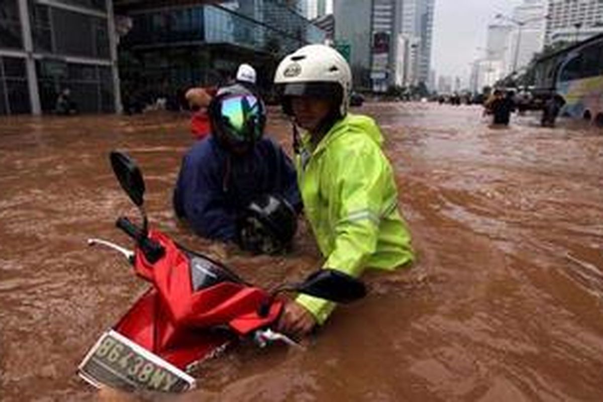 Anggota kepolisian membantu warga yang terjebak banjir di kawasan Bundaran Hotel Indonesia Jakarta, Kamis (17/1/2013). Banjir menggenangi jalan utama Jakarta dari Jalan Sudirman sampai depan Istana Negara RI.