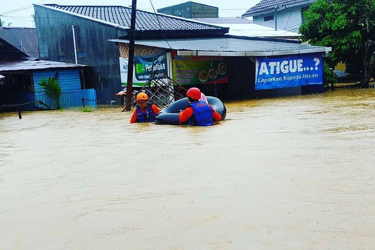 Petugas BPBD Tabalong berusaha menerobos banjir menggunakan ban untuk mencari warga yang hendak di evakuasi akibat banjir yang melanda 4 kecamatan di Kabupaten Tabalong, Kalsel, Minggu (9/2/2020).