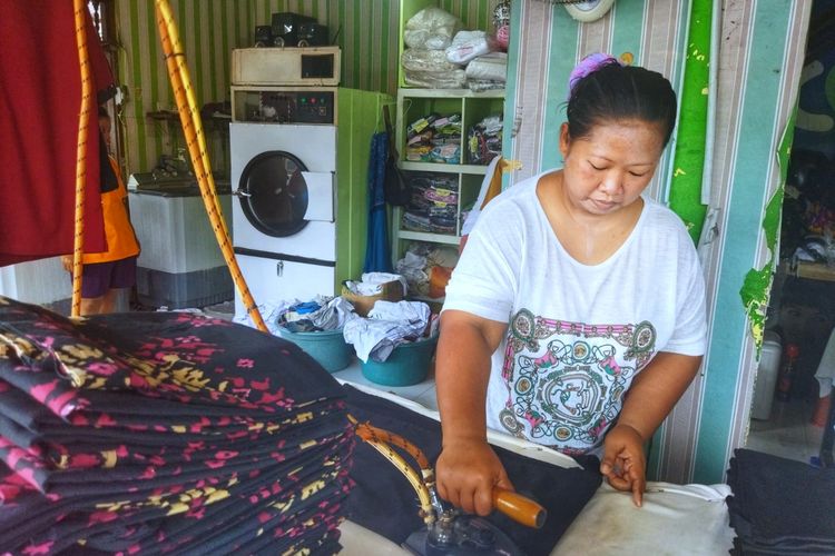 Salah satu pekerja di 'Yudi Laundry' sedang menggosok pakaian menggunakan setrika uap. Gede Suama, pemilik layanan penatu 'Yudi Laundry', mengaku alami kenaikan orderan hingga 200 persen karena perhelatan G20 di Bali.