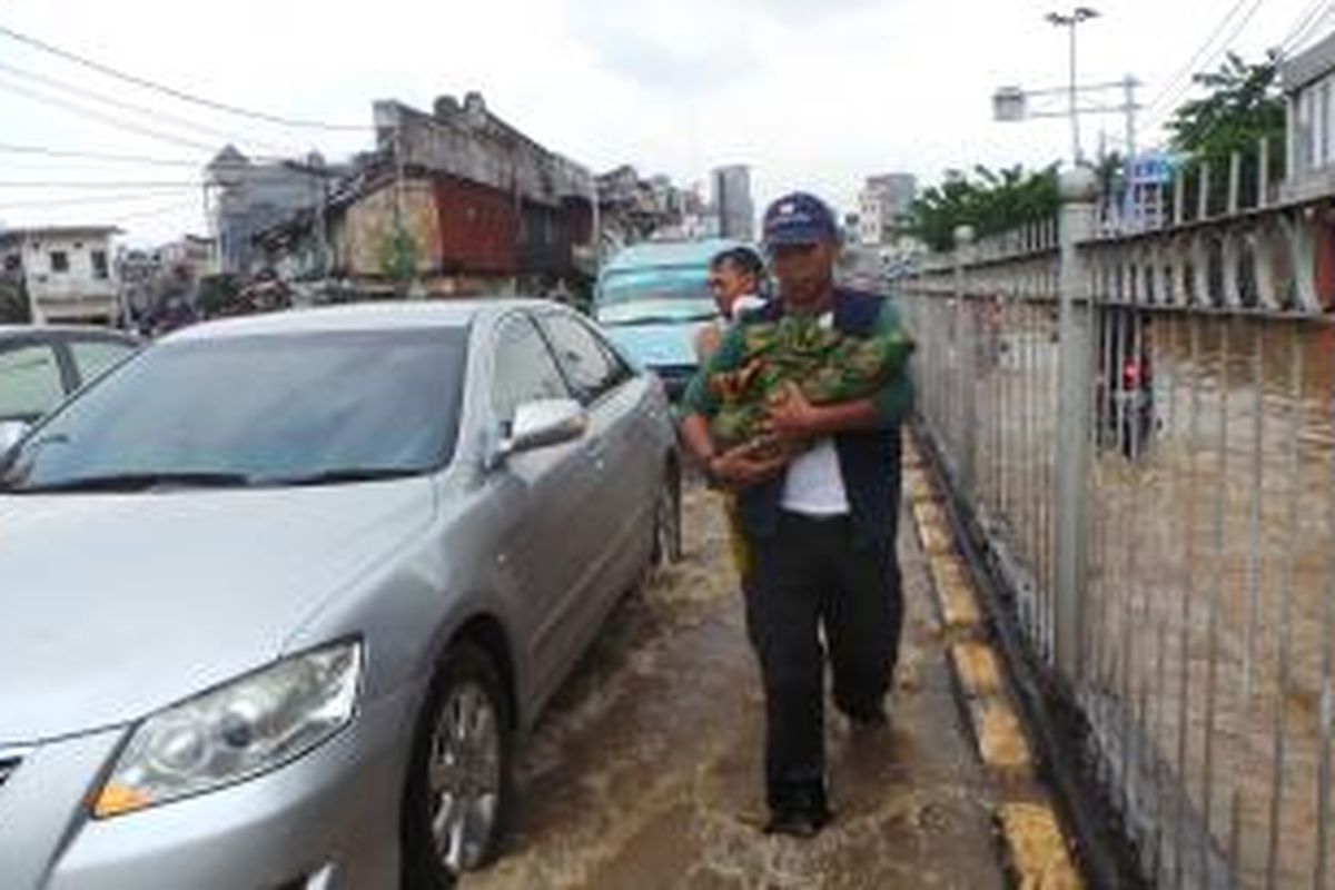 Balita berusia dua tahun diselamatkan dari banjir yang menerjang Kampung Pulo, Jakarta Timur. Kamis (20/11/2014).