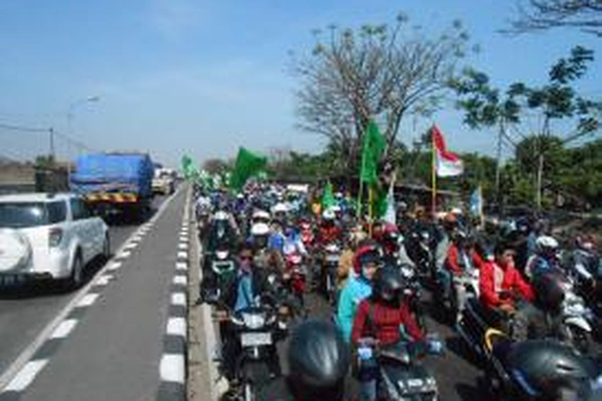 Aksi long march ribuan buruh yang tergabung dalam Gerakan Buruh Demak atau GEBRAK yang menuntut upah layak, memacetkan jalur pantura Demak, Selasa  (24/9/2013)